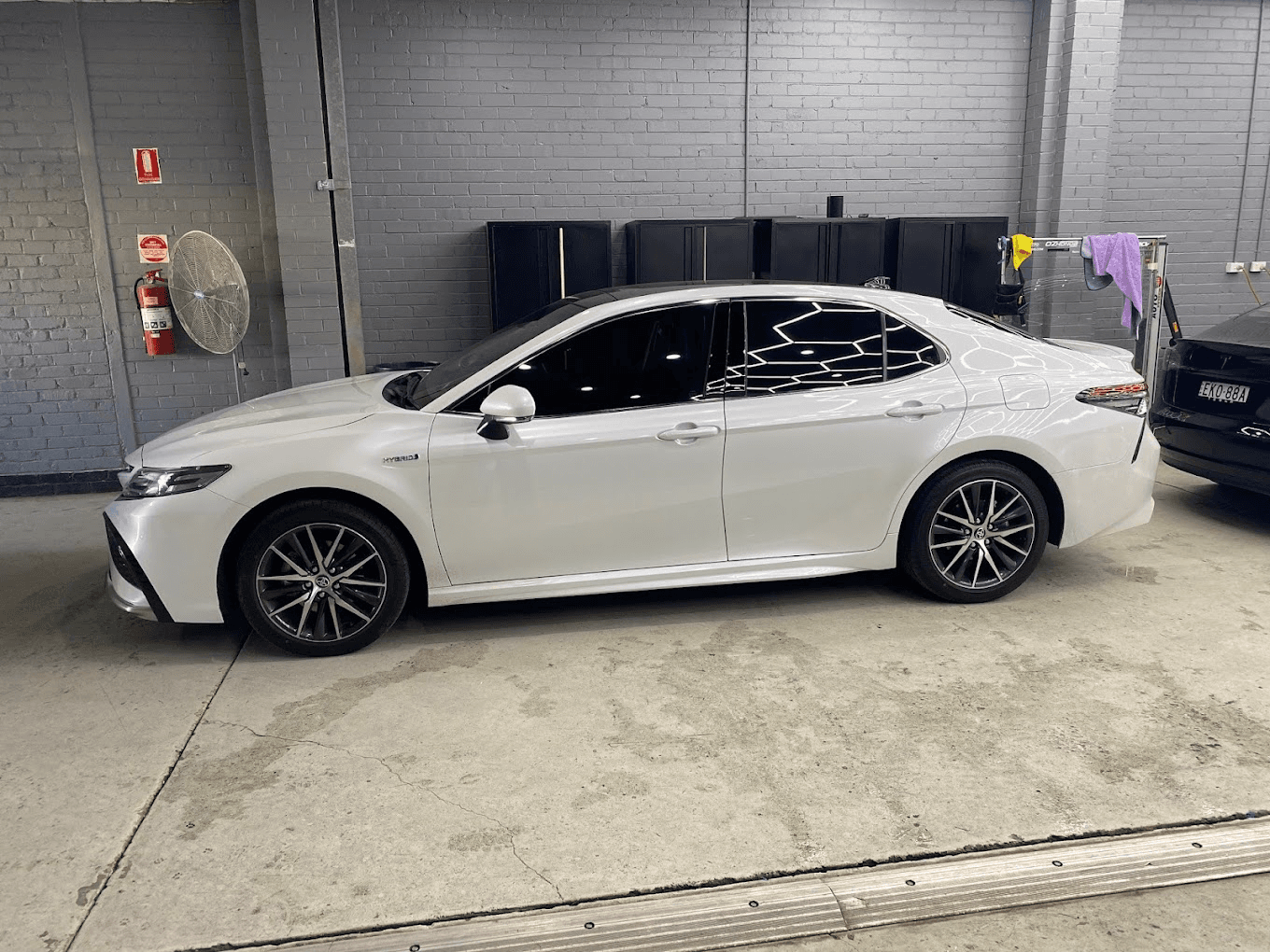 White Toyota Camry Hybrid with window tinting